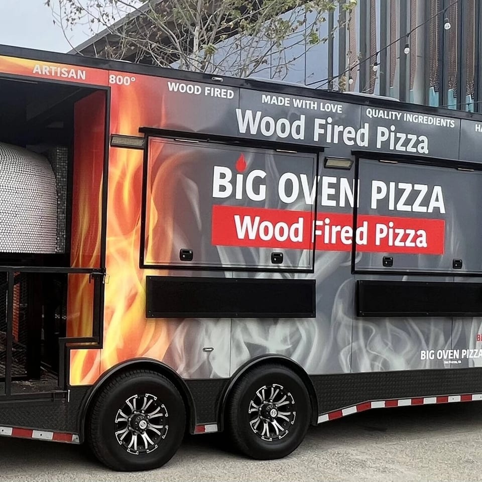 Big Oven Pizza mobile truck, with a wood-fired oven visible, ready for catering.