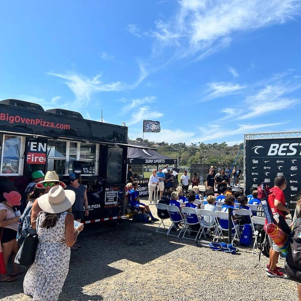 Big Oven Pizza food truck catering an outdoor event with people gathered and seated.