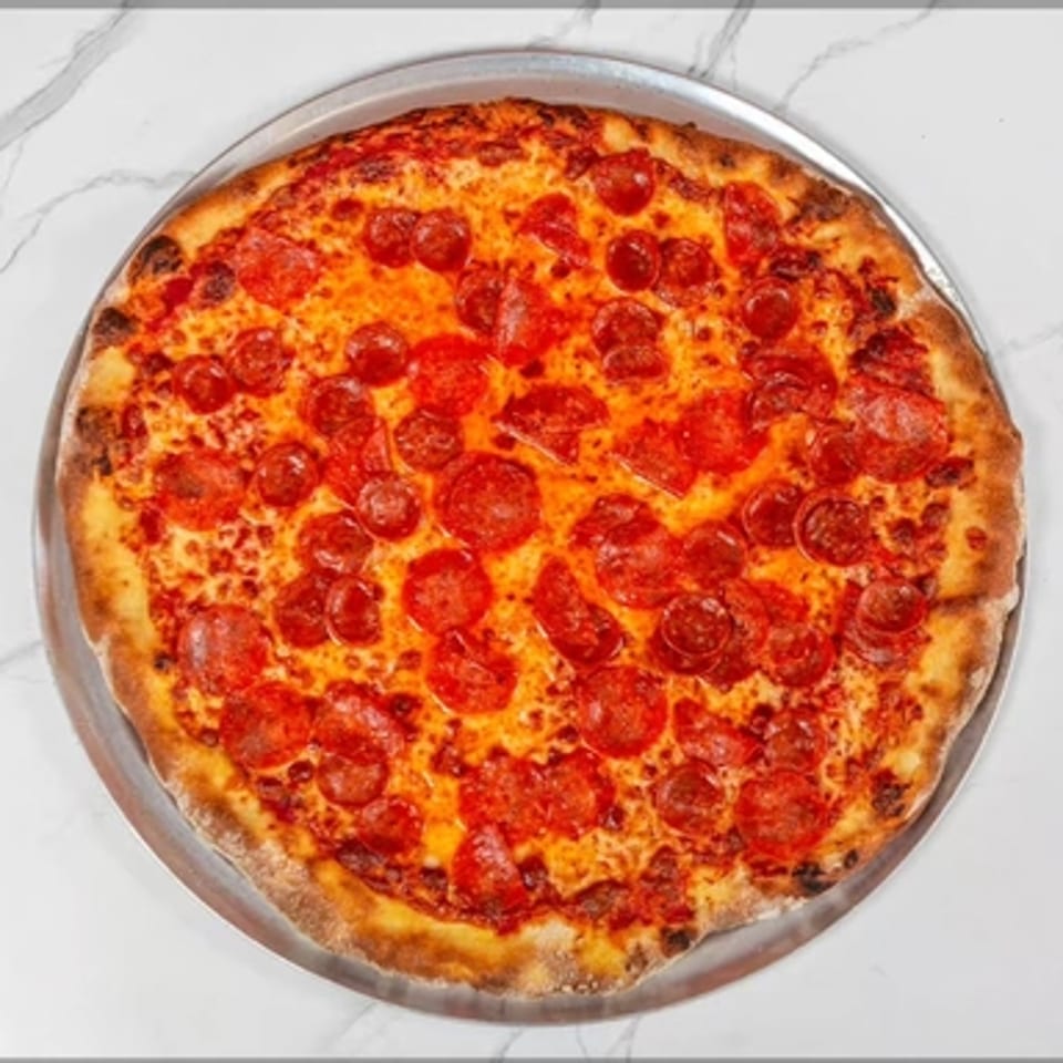 A whole pepperoni pizza from Big Oven Pizza Mobile Truck, on a metal tray, against a white marble background.