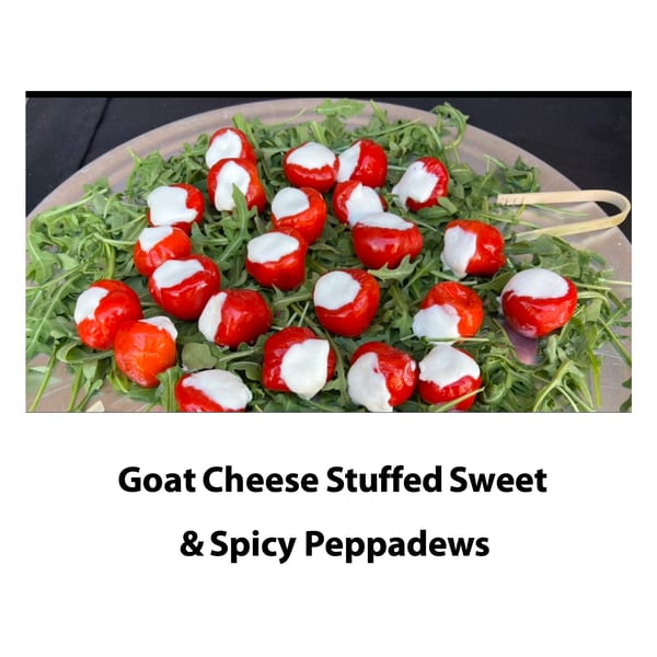 Red peppadews stuffed with white goat cheese, arranged on a bed of green arugula.