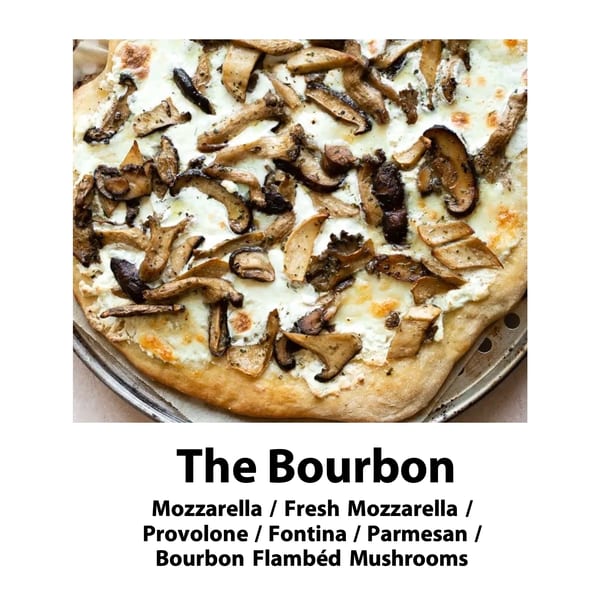 Close-up of a Bourbon pizza with white cheese and bourbon flambéed mushrooms on a metal pan.